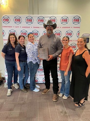 Garrett rcieves his 2025 EVT of the year award accompanied bu family and co-workers.