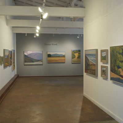 An art gallery with Thomas Wood's paintings on display.