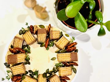 Coffee and pecan cake, decorated with caramel wafer biscuits, pecans, pumpkin seeds and thyme.