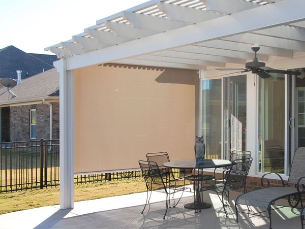 White pergola with sand colored solar shade blocking the sun on the side