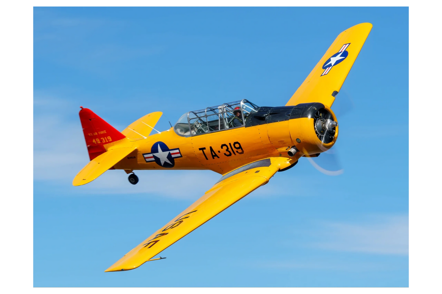 Photo of a yellow T-6 Texan warbird in flight.