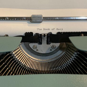 Close view of vintage typewriter with the words The Book of Mary typed on the page