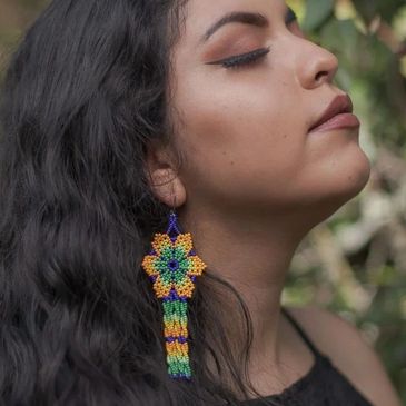 A model with a flower earring made with beads.