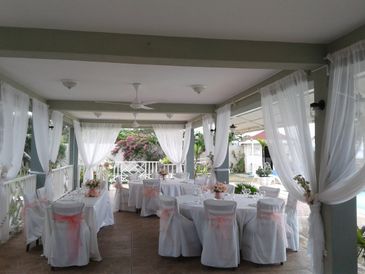 Wedding reception in outdoor, covered dining area at Pipers Cove hotel