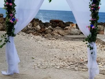 Floral arch for afternoon beach marriage ceremony.