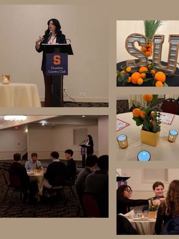 A speaker at Drumlins Country Club event with audience and orange-themed decor.