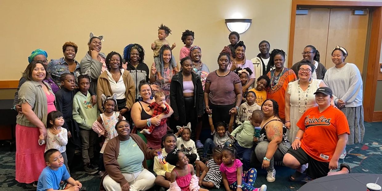 D4A members and their family members of all ages gather, smiling in a joyful group at a retreat.