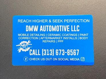 Business card for DMW Automotive LLC with contact details.