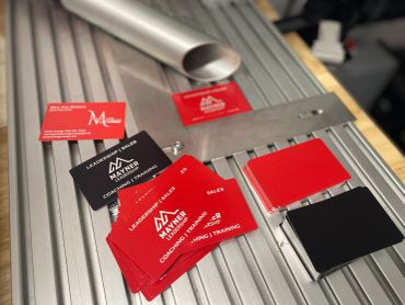 Business cards and metal tools on a table.