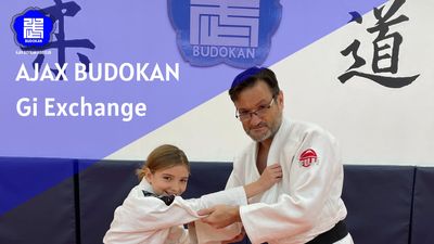 Two people demonstrating a judo move in a dojo.