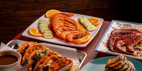 Shrimp dish with tacos and octopus on a table.