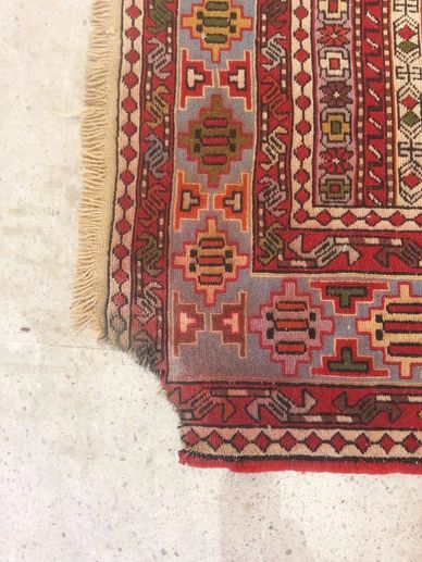 Damaged rug with edge torn, which was later restored by Sheba Iranian Carpets Stores