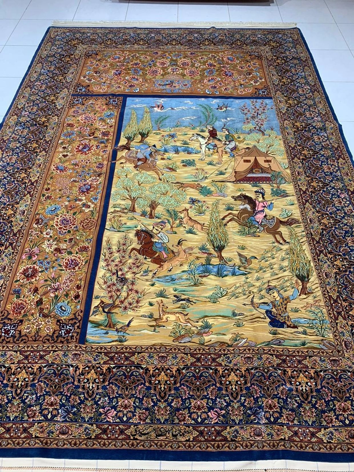 Magnificent handmade hand knotted asymmetric Qom silk Persian rug with hunting design featured.