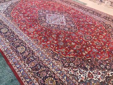 Kashan red handmade hand knotted wool carpet. Colors blue, red, navy with medallion and border.