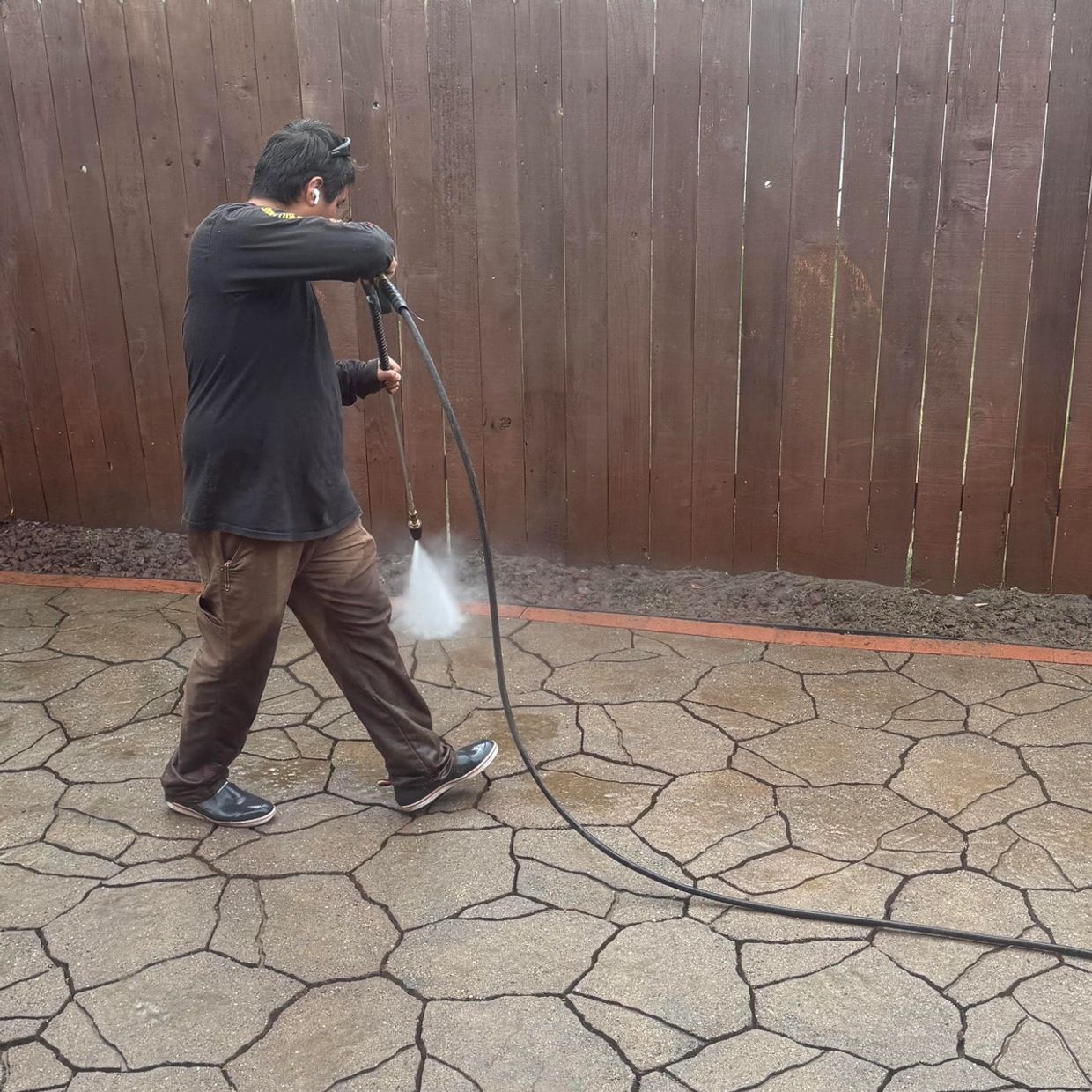 Owner and operator, Alexis Torres Diaz, pressure washing patio pavers.
