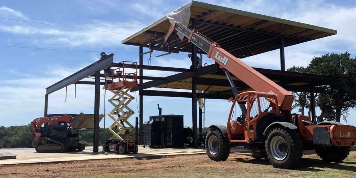 Construction site with metal framework and heavy machinery.