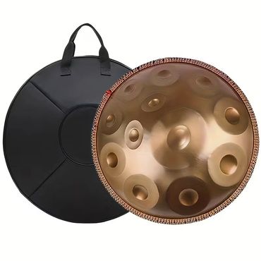 A bronze handpan drum with a black carrying case.