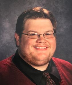 A Headshot of A Man With Glasses