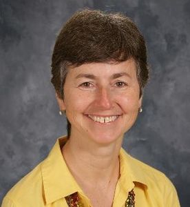 A Headshot Of A Woman In A Yellow Shirt