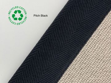 Close-up of pitch black recycled cotton fabric with recycling symbol.