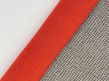 Close-up of three fabric textures in white, carrot orange, and gray.