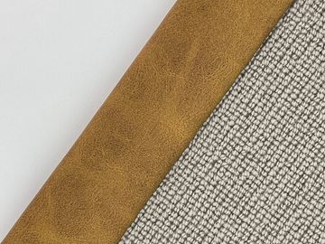 Close-up of an almanac with a brown leather spine and textured gray cover.
