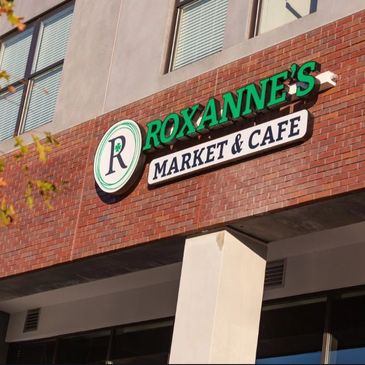 Roxanne's Market & Cafe sign on a brick building.