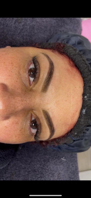 Close-up of a face showing well-groomed eyebrows and long eyelashes.