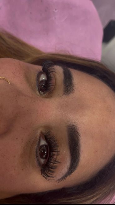 Close-up of eyes with long eyelashes and natural eyebrows.