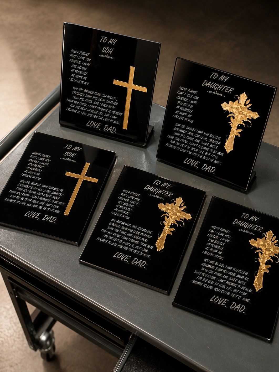 Black plaques with golden crosses and heartfelt messages from a dad to his son and daughter.