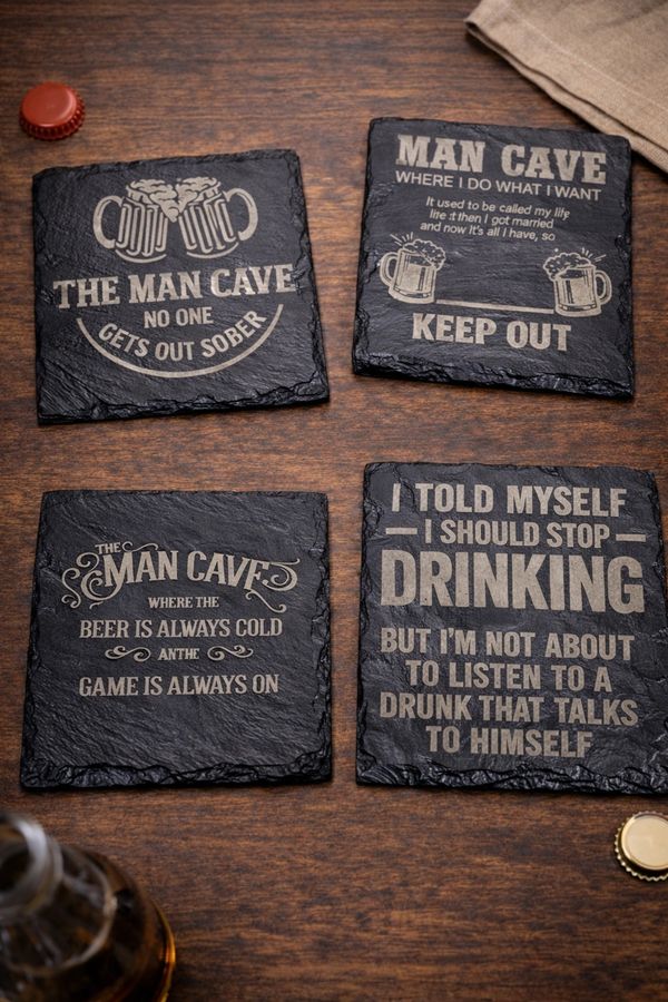Set of four humorous 'Man Cave' coasters with drinking-related quotes on a wooden table.