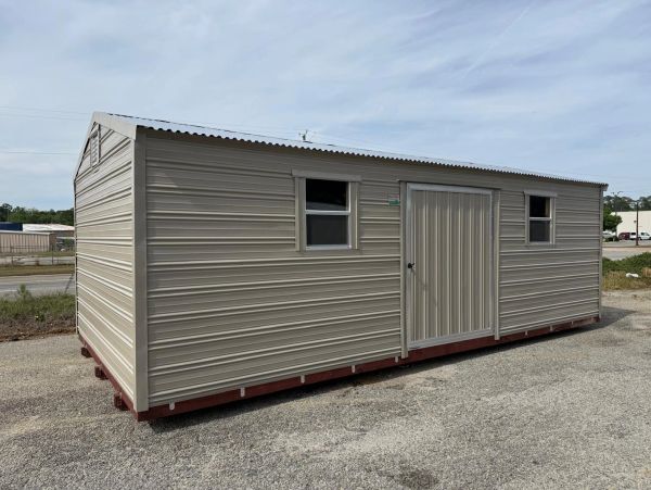 A beige metal storage shed with two windows and a central door.