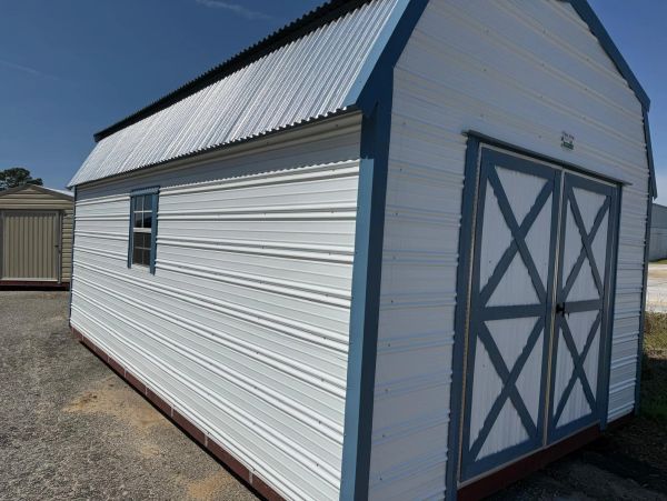 White metal storage shed with blue trim and double doors.