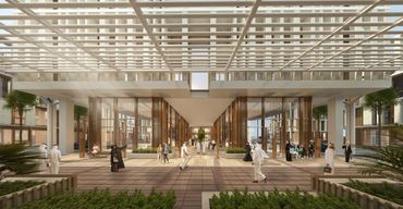 Modern architectural corridor with people walking and socializing under a geometric roof structure.