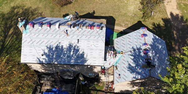 Installing weather shield on two different roofs on one property before installing shingles.