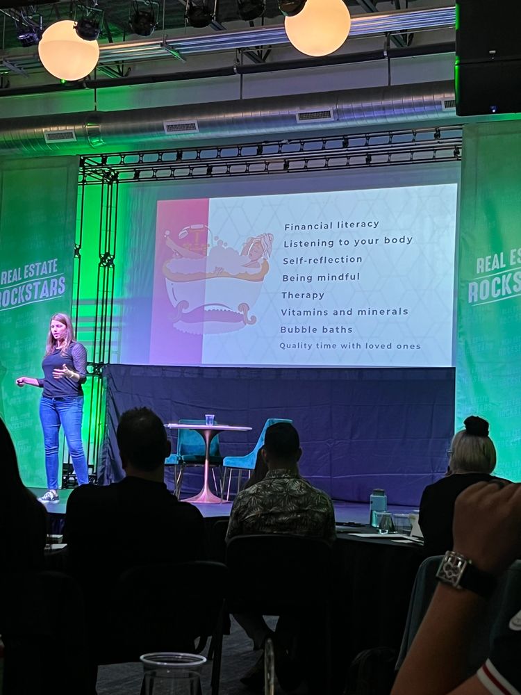 Stephanie Heiser on stage at the Real Estate Rockstars Mastermind that she coordinated