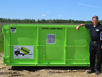 Man standing next to 10 yard dumpster