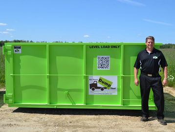 Man standing next to 15 yard dumpster