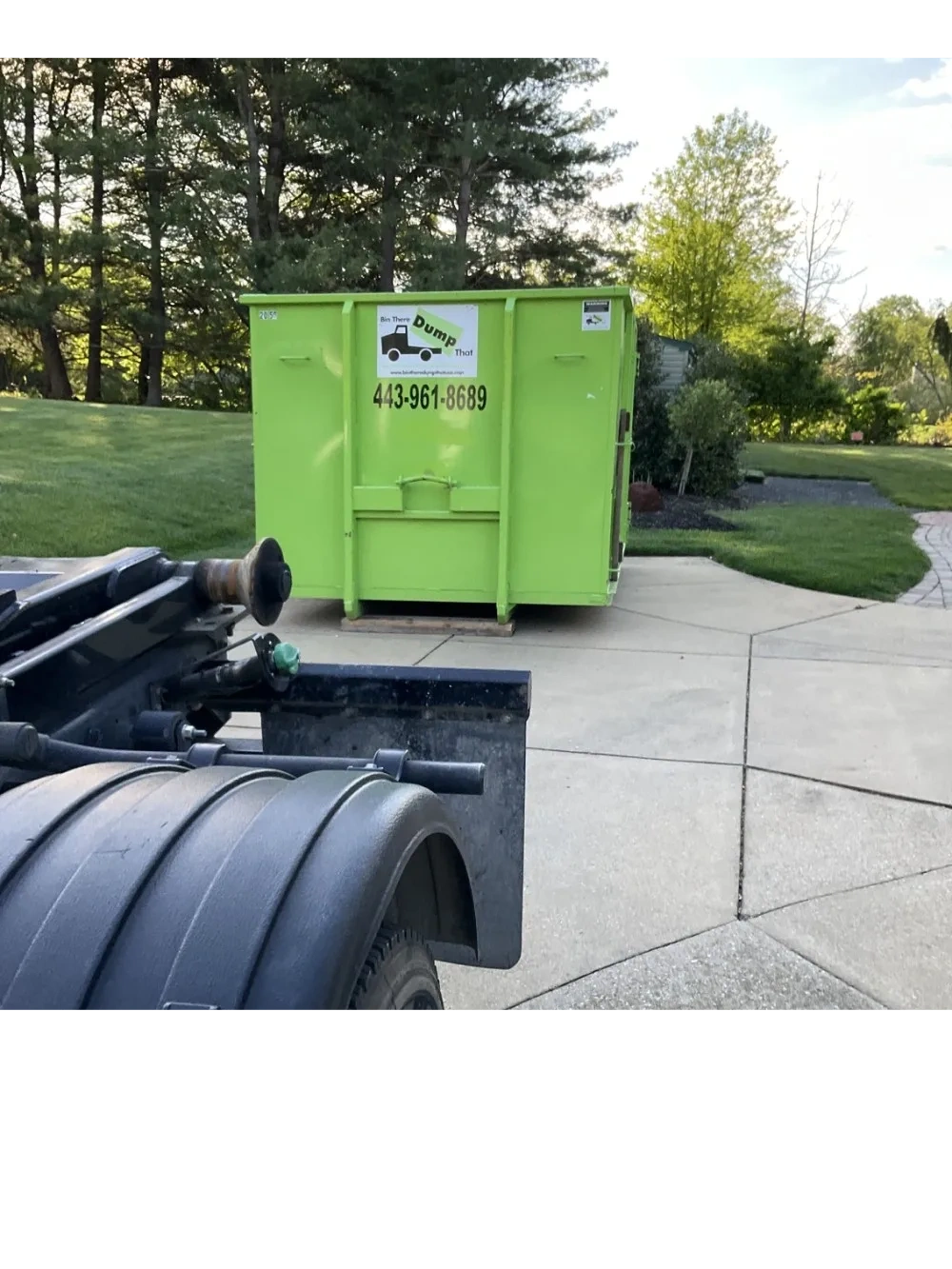 Green 20 yard dumpster placed on driveway protection boards on a customer's driveway