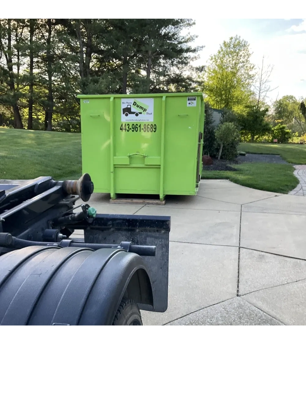 Green 20 yard dumpster placed on driveway protection boards on a customer's driveway 