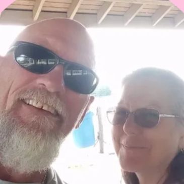 A smiling couple wearing sunglasses, enjoying a sunny day