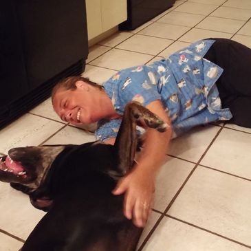 Women playing with a dog on the floor