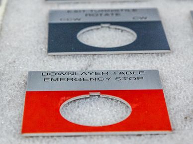 Custom laser cut and laser engraved safety tags for industrial equipment.