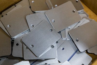 Custom cut and hole punched brushed stainless steel, ready to be laser engraved as asset tags.