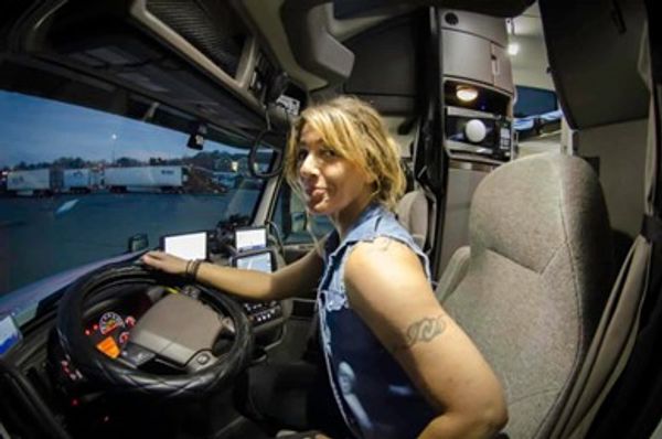 woman sitting in the driver's seat of a semi
