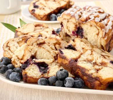 Slices of blueberry cinnamon swirl bread with fresh blueberries.