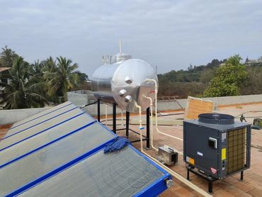 Solar water heating system installed on a rooftop with storage tank and heat exchanger.