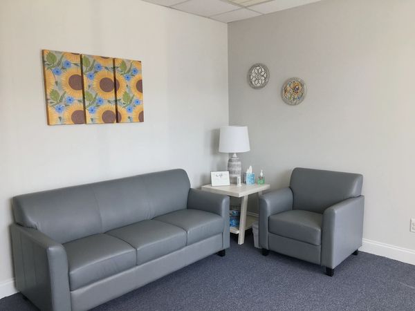 Reception area with couch, chair, end table, lamp