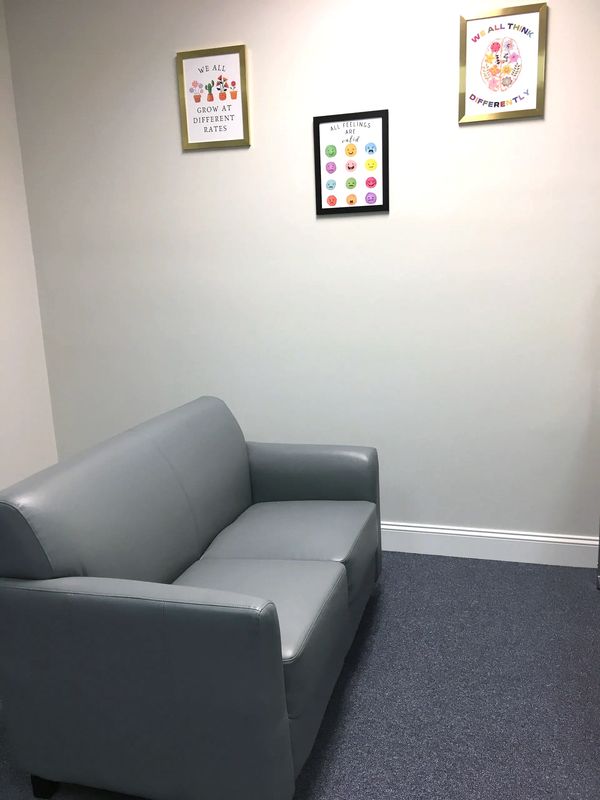 Small couch with pictures on wall