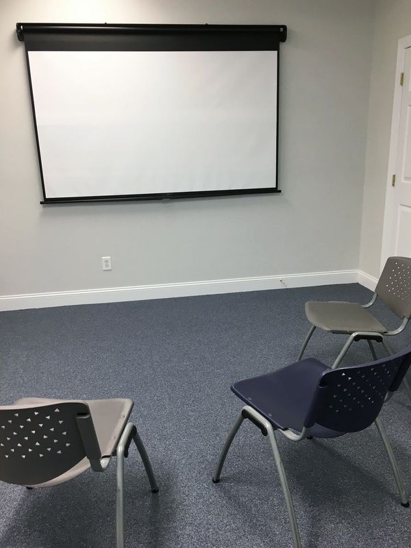 Projector screen with chairs in circular pattern